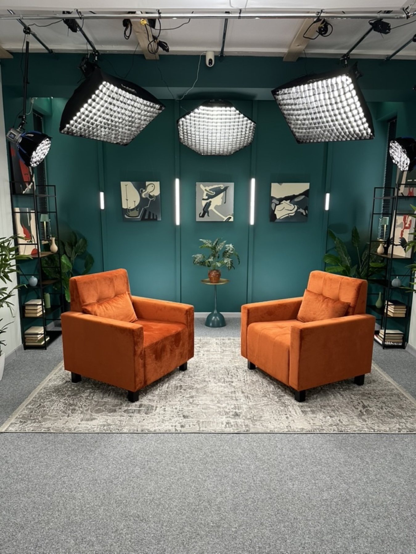 Green Room Studio 312 з бірюзовою стіною та помаранчевими кріслами